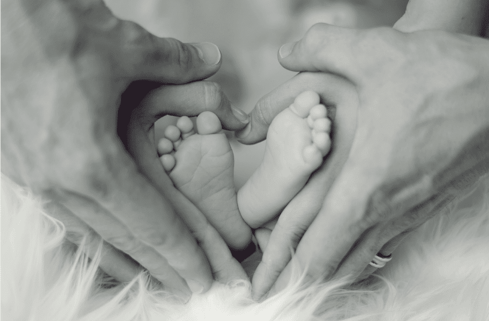 A baby 's feet are being held between two hands.