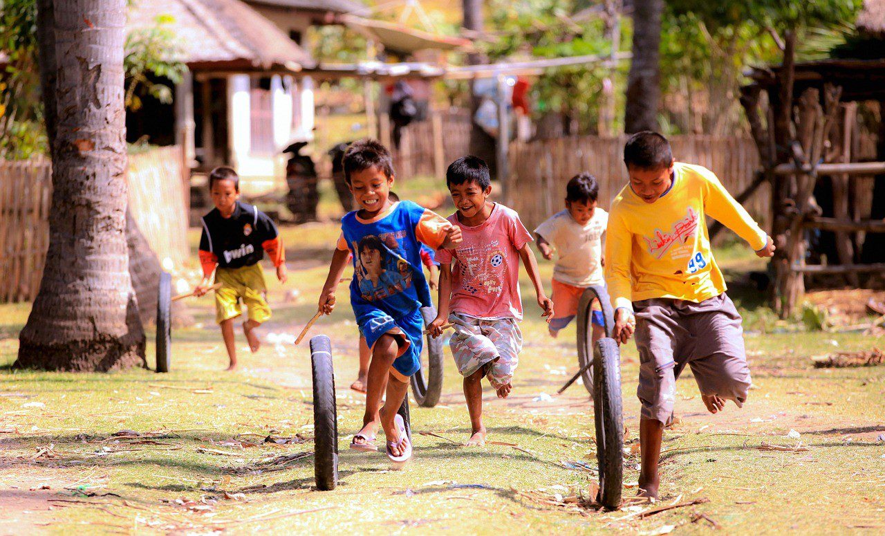 A group of children playing with bikes in the dirt.